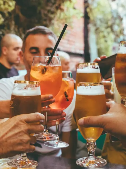 cheers. people clinking beer glasses outside pub