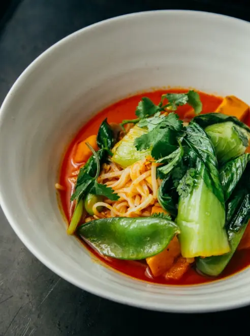 a bowl of thai noodles and pak choi