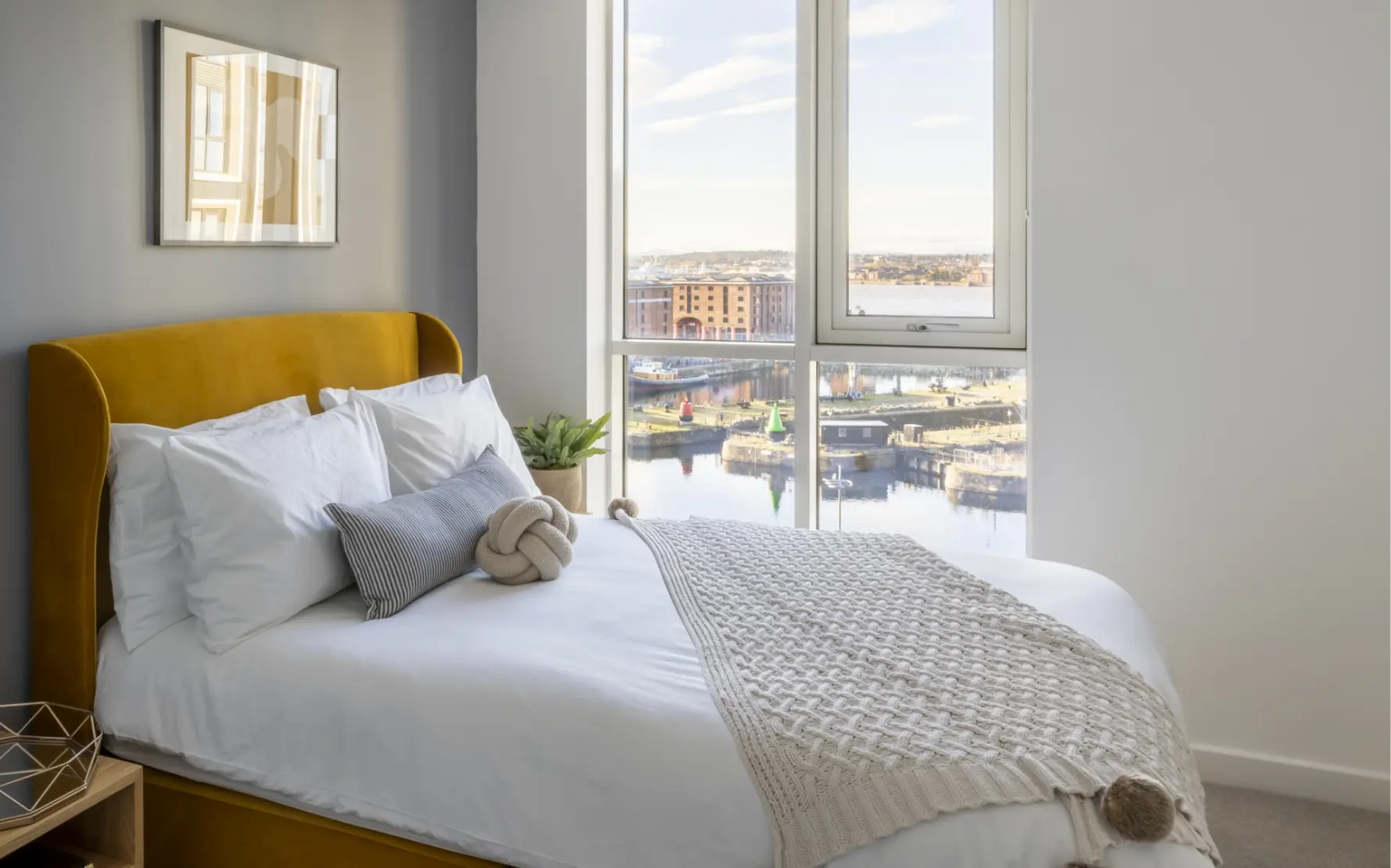 Double bed and window behind with views of the Mersey