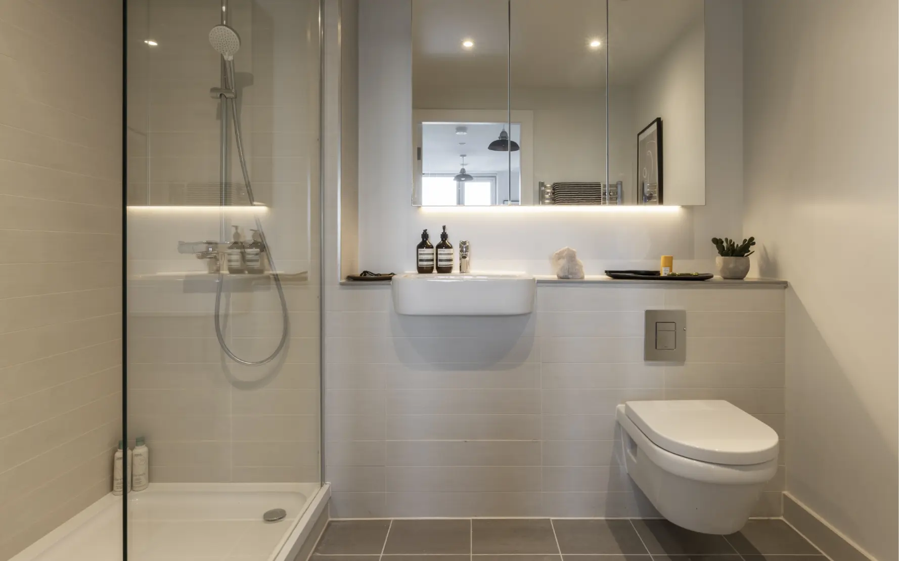 bathroom in one bed apartment, shower, bath, sink and mirror