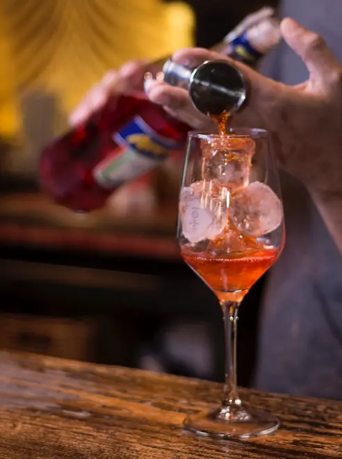a bar person making a cocktail at the bar